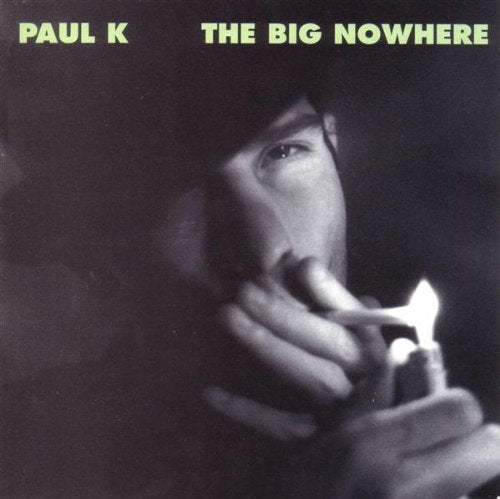 CD cover: Paul K, man lighting a cigarette in darkness.
