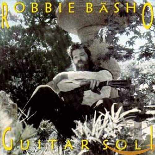Robbie Basho sitting outdoors with an acoustic guitar, album cover art.