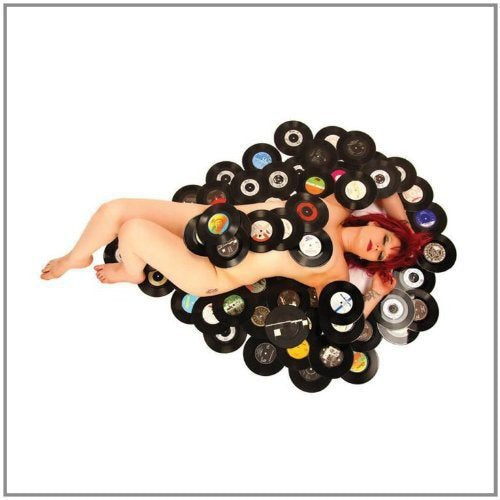 Nude woman surrounded by vinyl records, with "The Media Whores" text above her.