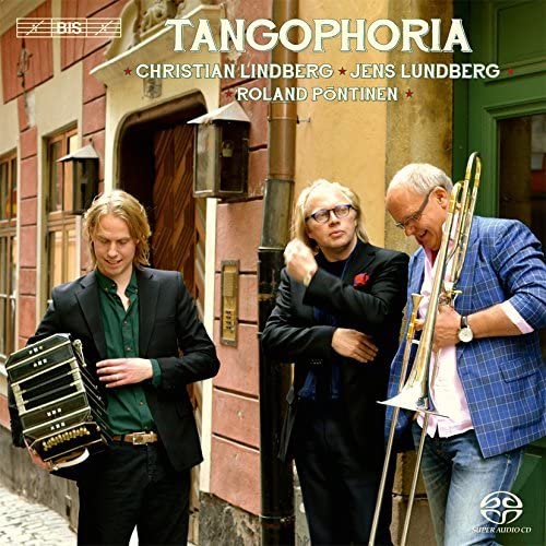 Three musicians with accordion and trombone stand outside a building.