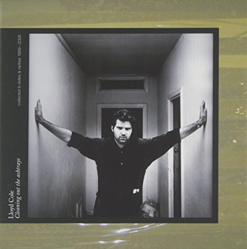 "CD cover with a man in a hallway, arms outstretched, on a greenish background."