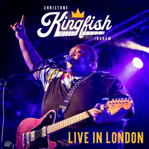 Christone “Kingfish” Ingram performing live with a guitar and microphone.