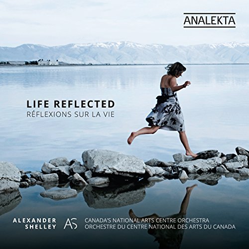 "CD cover featuring a woman leaping on rocks by a serene lake."