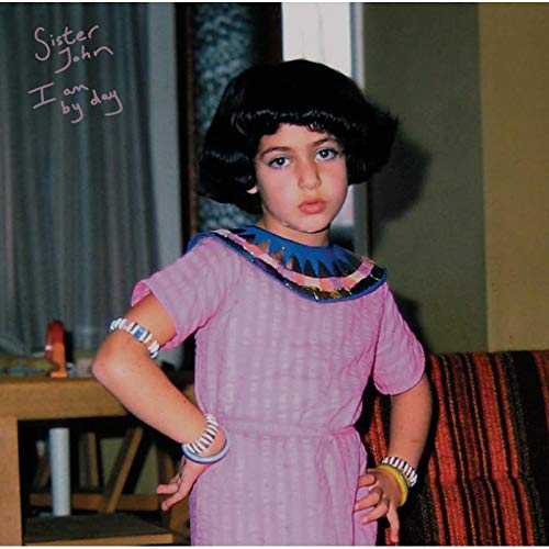 Album cover: young girl with dark curly hair in a pink dress.