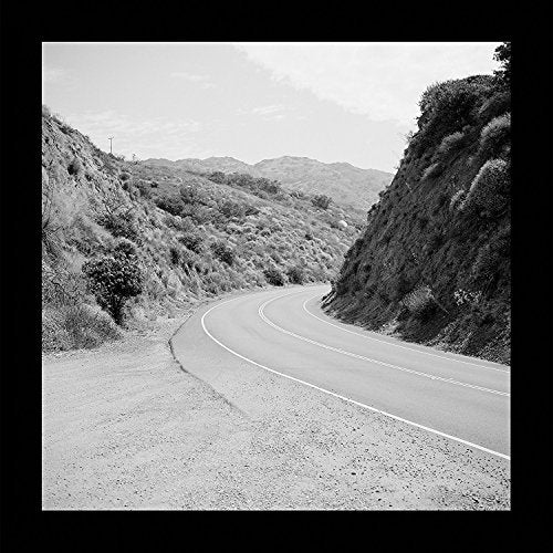 Black and white landscape photograph of a winding road through hills.