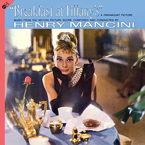 Audrey Hepburn sits at a table in the Breakfast at Tiffany's soundtrack album cover.