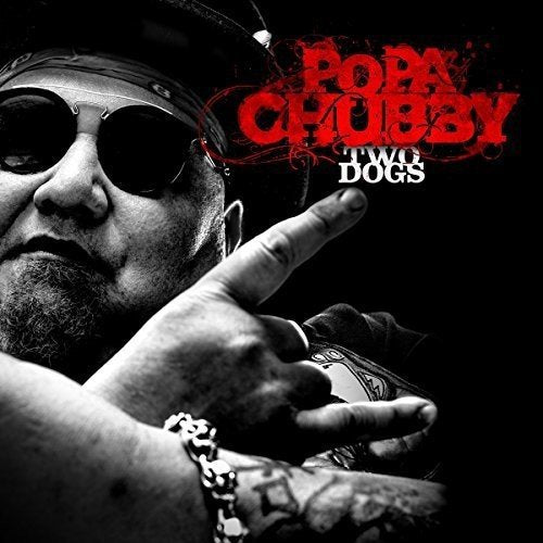 "Album cover with a man wearing sunglasses and making a gesture, against a black background."