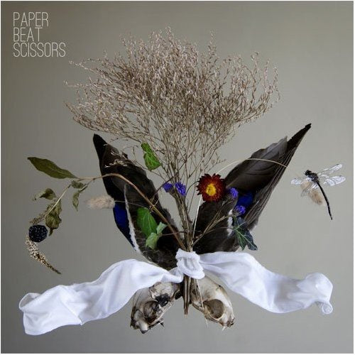 "Album cover with bouquet of dark leaves, flowers, and animal skull, tied with white cloth."