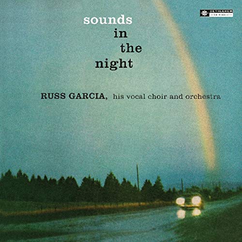 Vinyl album cover with a car driving at night under a rainbow.