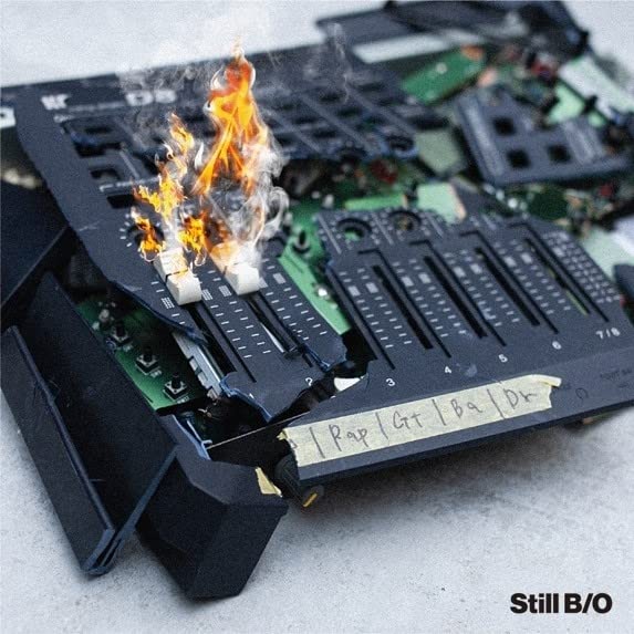 CD case with burning electronics and handwritten text, album art.