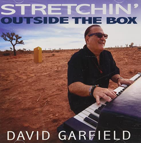David Garfield at a piano in a desert landscape, album cover.