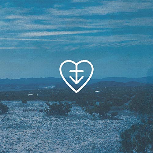 A white heart-shaped logo with a cross is overlaid on a blue-toned desert landscape.