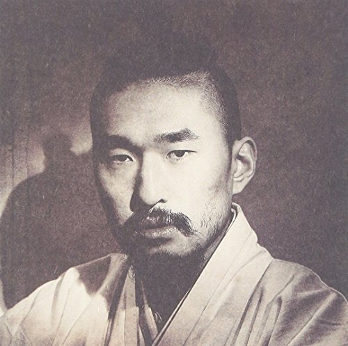 Sepia-toned portrait of a man with a mustache and traditional hairstyle.