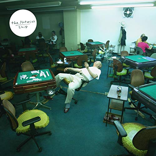 "Vinyl record cover featuring a man slumped over a poker table in a dimly lit room."