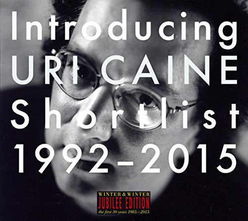 "Black and white CD cover featuring a close-up of a man's face wearing glasses."