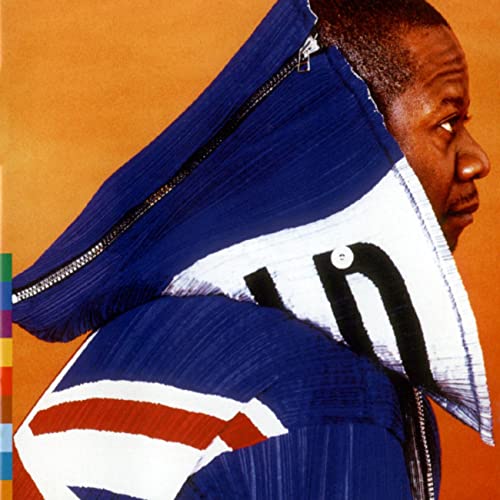 Papa Wemba in profile, wearing a blue and white striped jacket with a large collar.