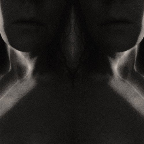A black-and-white close-up image of a person's chest and chin, obscured and distorted.