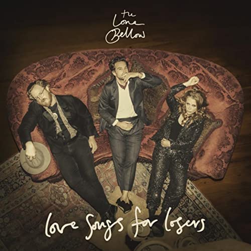 CD cover: three people in suits on a worn, red velvet couch.