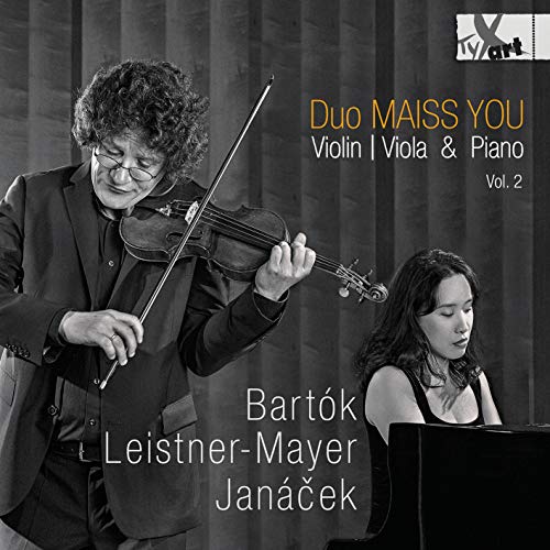 Black and white image of a man playing violin beside a seated pianist.