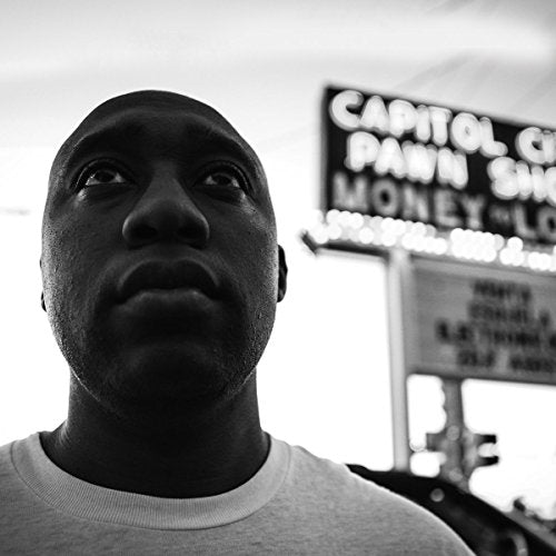 "Black and white image of a man in front of a pawn shop sign."