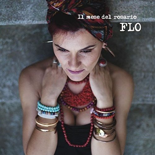 CD cover featuring a woman adorned with colorful jewelry and a headscarf, against a gray background.