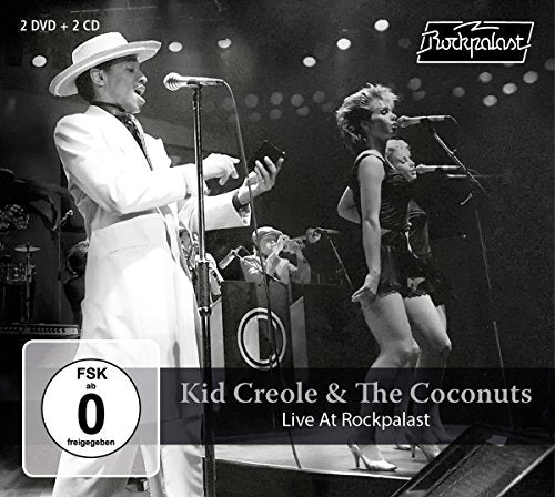 Black-and-white image of Kid Creole and the Coconuts performing on stage with backup singers.