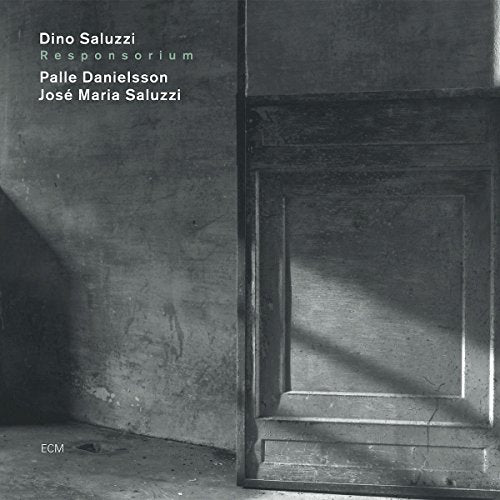 "Black and white album cover with doorway and shadow, featuring artist and title information."