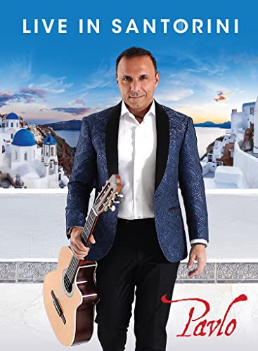 Pavlo holding a guitar, Santorini buildings in the background.
