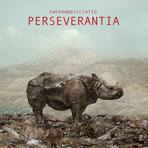 Album cover featuring a rhinoceros in a rocky, mountainous landscape.