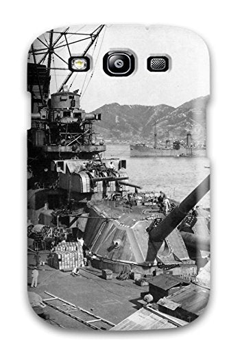 Black and white photo of a battleship with a harbor backdrop.