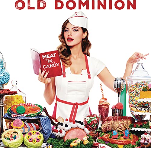 Woman in chef's hat holds book amidst sweets and meats.