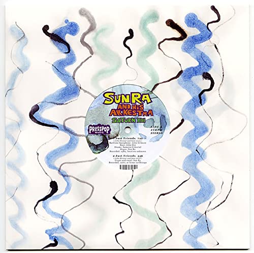 Vinyl record with abstract blue and green swirls, "Sun Ra" label visible.