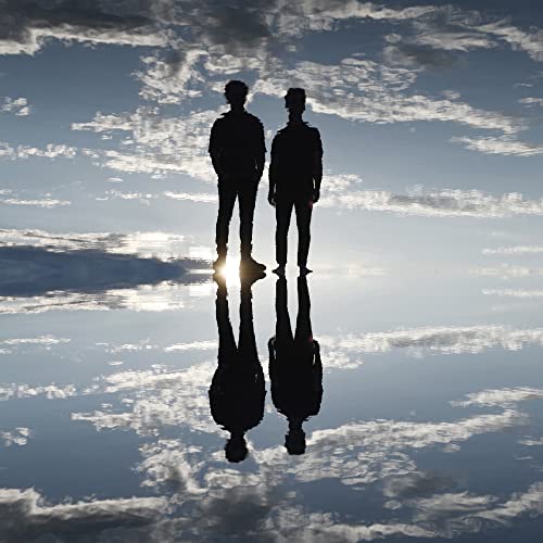 Silhouettes of two men reflected in a cloudy, watery surface.