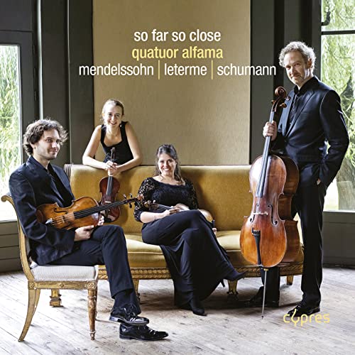 Classical musicians with string instruments posing on a yellow couch.
