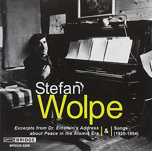 Black and white image of a man sitting by a piano with sheet music.