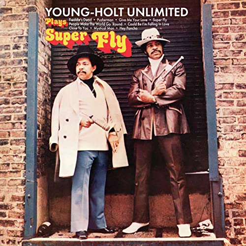 CD cover: two men in hats and coats stand before a brick wall.