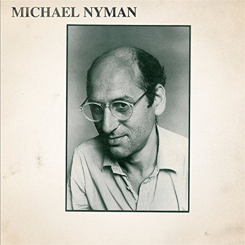 Black and white portrait of composer Michael Nyman wearing glasses.
