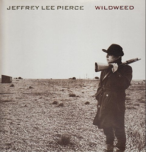 "Vinyl record cover featuring a man holding a rifle in a desert landscape."