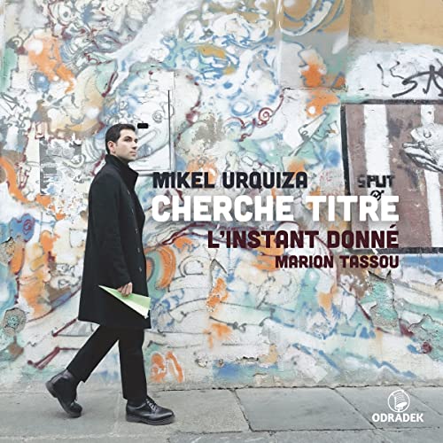 CD cover: man in coat walking past colorful graffiti wall.