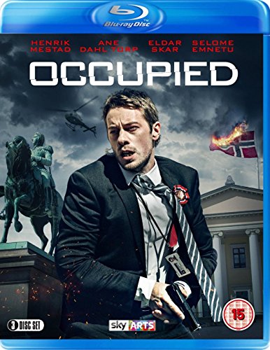 "Blu-ray cover of 'Occupied' featuring a man in a suit holding a gun."