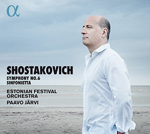 Man in white shirt stands on beach, facing left, with text overlay on the left.