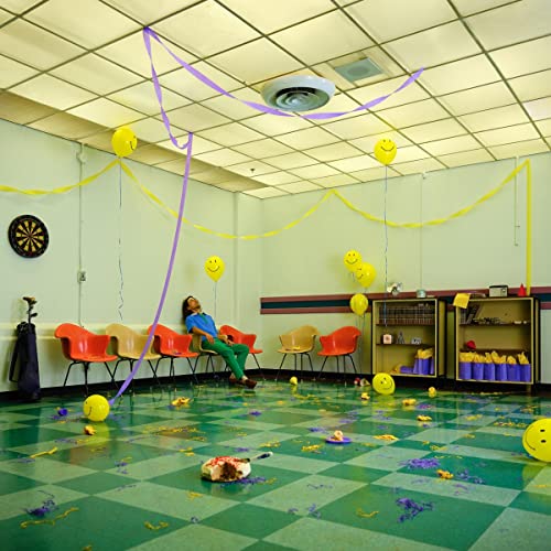 Woman lying amongst balloons and confetti in a decorated room.