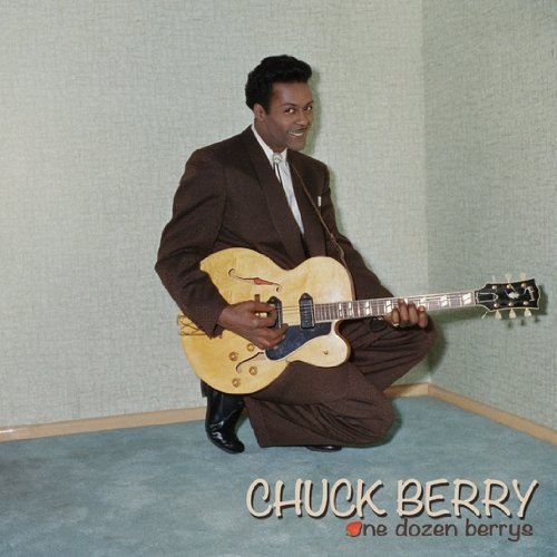 Chuck Berry in brown suit, kneeling and playing a hollow-body guitar.