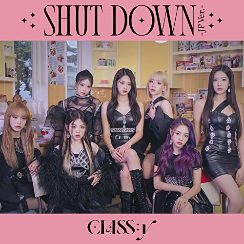 Six women in dark outfits pose in a brightly lit kitchen scene.