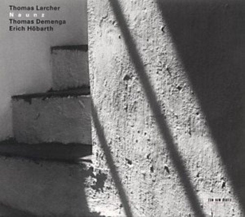 Black and white album cover with stairs and diagonal shadows, featuring artist names.