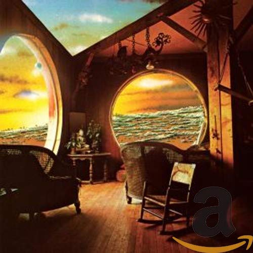 Room with arched windows overlooking ocean and sunset scene.
