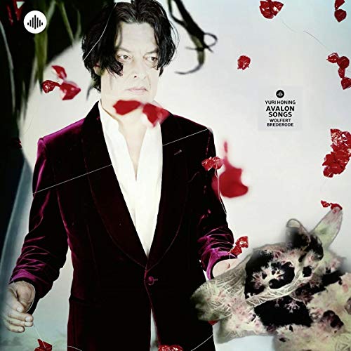 Man in a velvet suit with falling red shapes and a cat portrait.