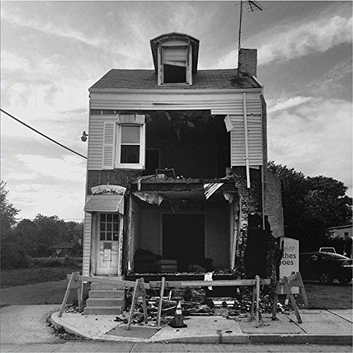 Black and white photo of a severely damaged two-story house.