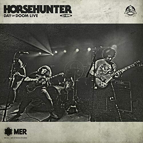 Black and white album cover featuring a live band performing on stage.