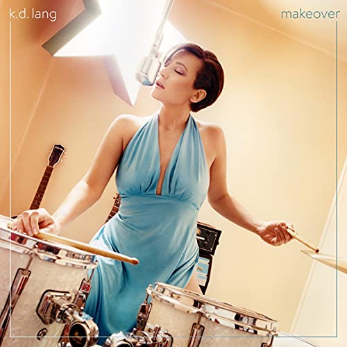 k.d. lang in blue dress playing drums, album cover for "makeover".